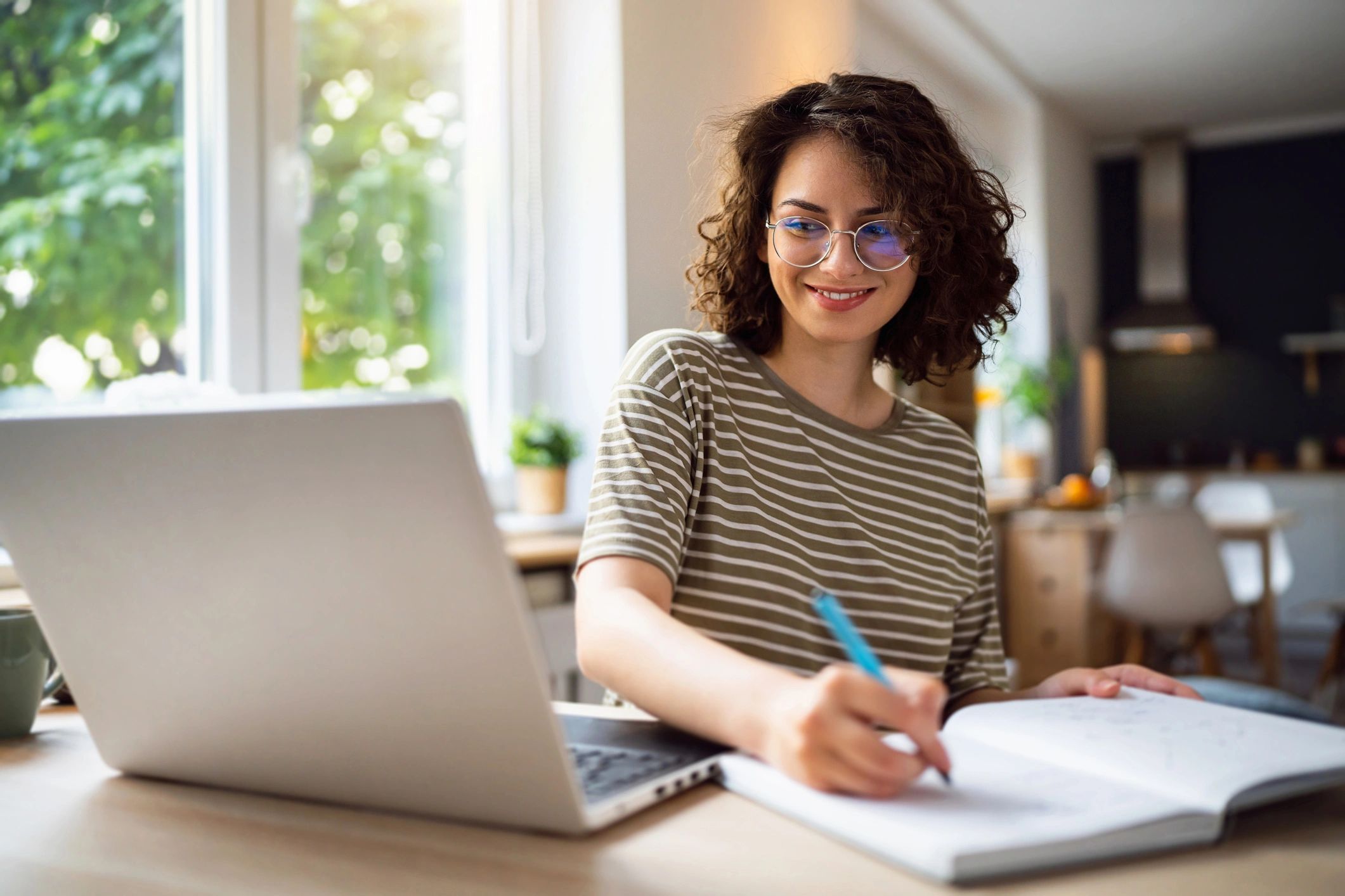 Student planning a study schedule with a laptop and notebook